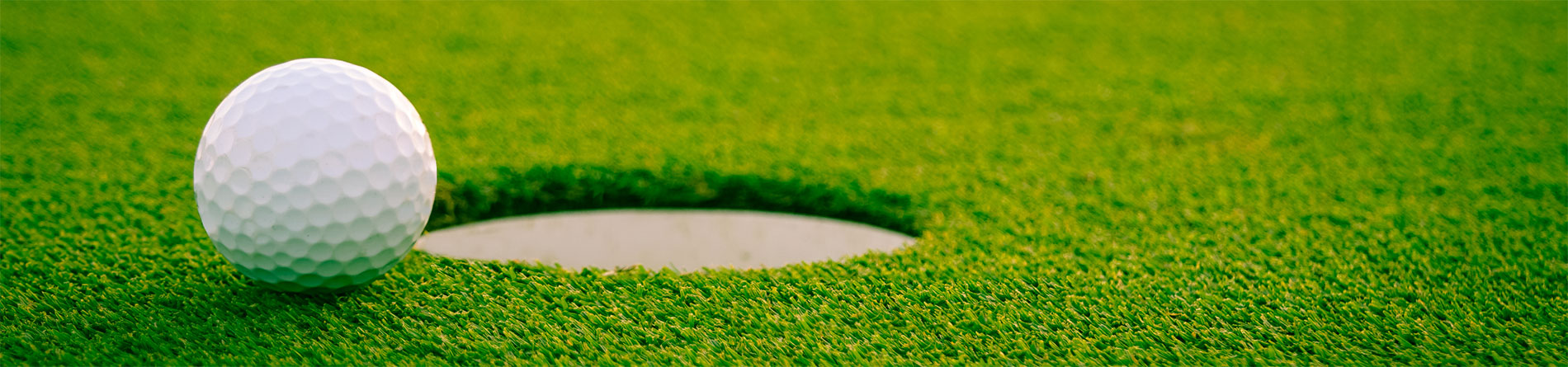 golf course with a golf ball near a hole